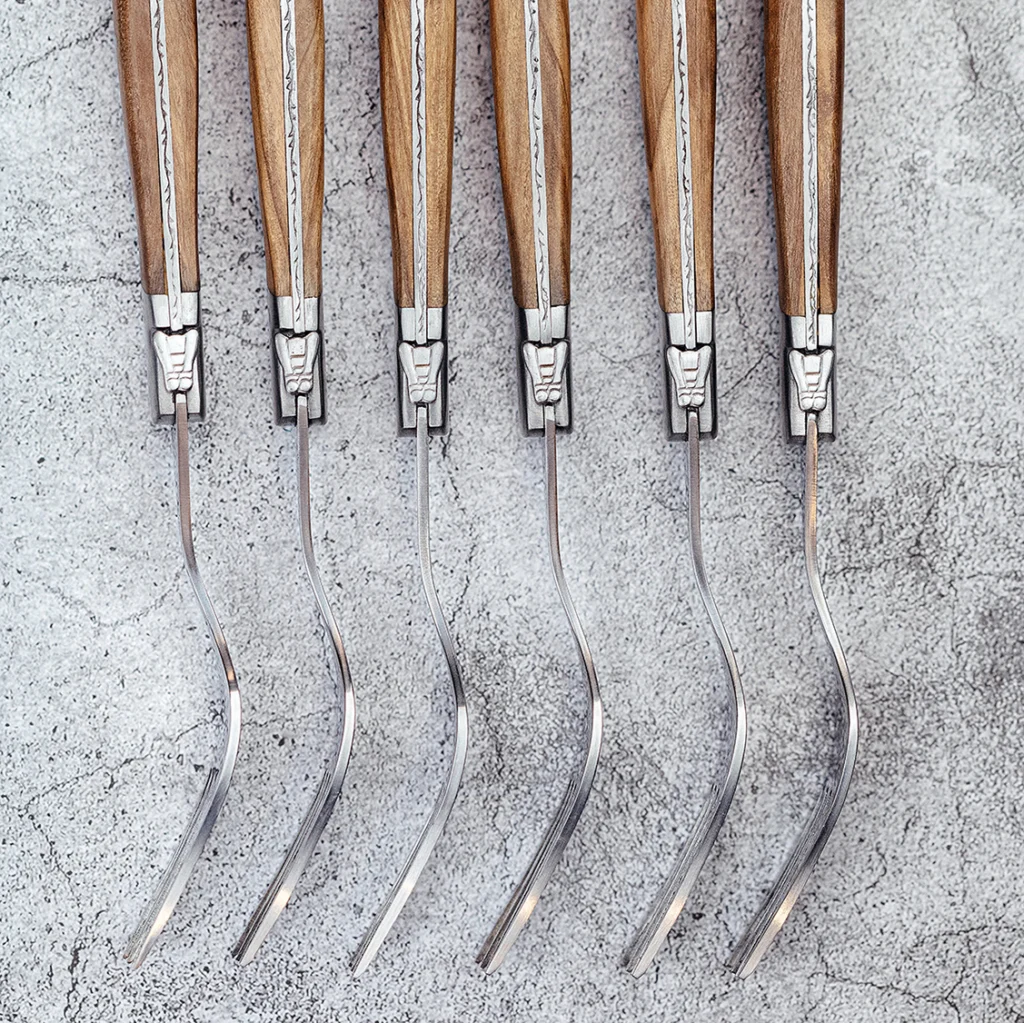 Six Laguiole Du Monde Exclusive forks with olive wood handles, top view