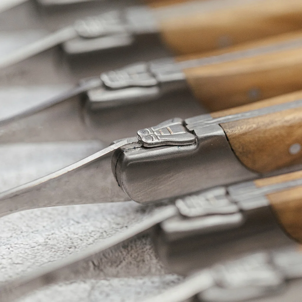Close-up of the bee detail on Laguiole Du Monde forks with olive wood handles